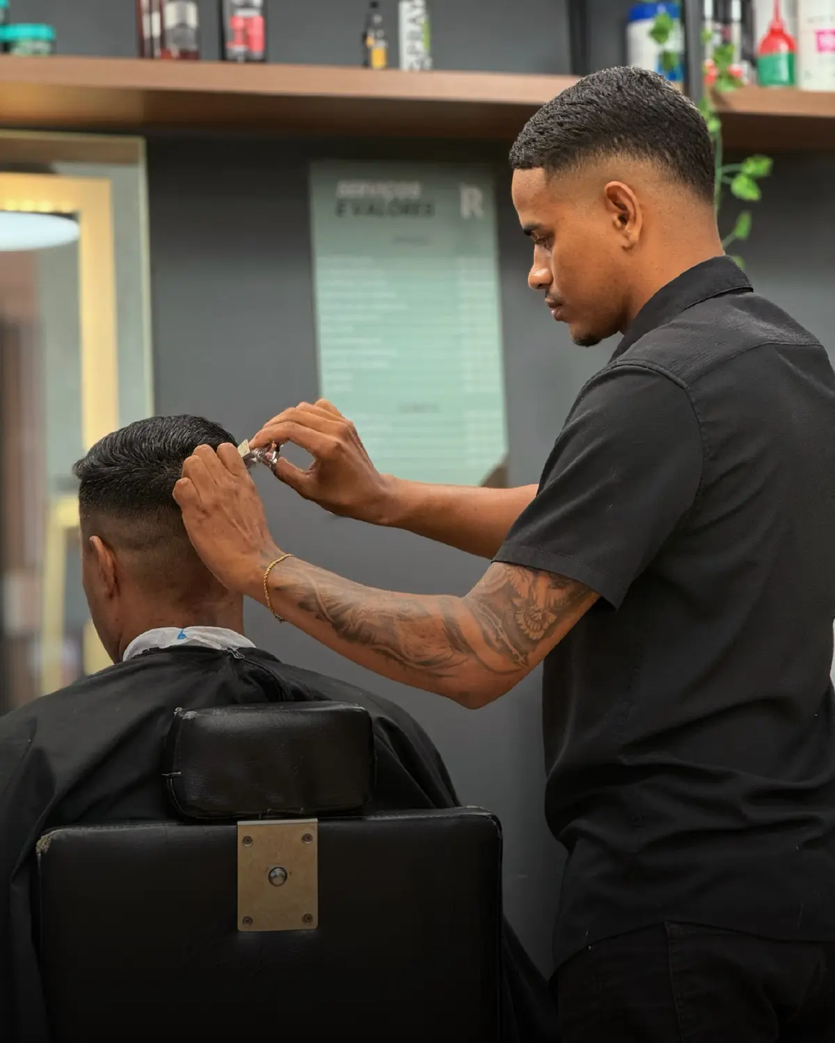 Barbeiro realizando acabamento no cabelo do cliente